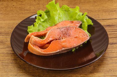 İki pembe somon balığı bifteği. Salata yaprağı.