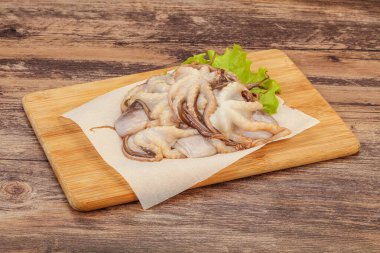 Çiğ deniz ürünleri - ahtapot tahtada pişirmek için.