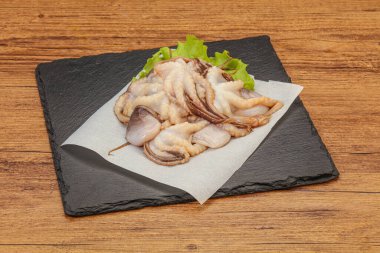 Çiğ deniz ürünleri - ahtapot tahtada pişirmek için.