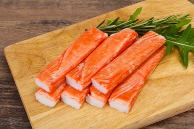 Ahşap tahtanın üzerinde yengeç çubuğu surimi