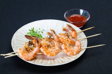 Baharatlı soslu ızgara karides şişi.