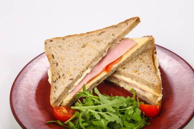 Jambonlu ve peynirli sandviç roka servis edildi.