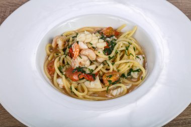 İtalyan spagettisi, deniz ürünleri ve bitkilerle.