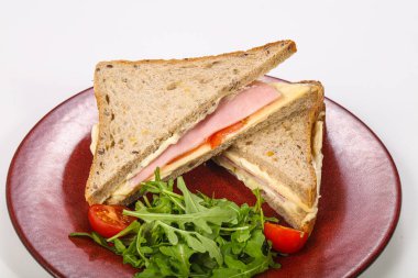 Jambonlu ve peynirli sandviç roka servis edildi.