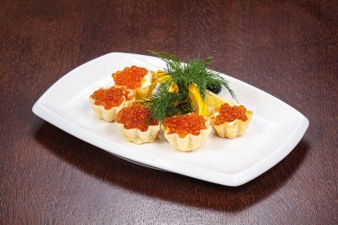 Kırmızı havyar kanepesi dereotu ve limon servis ediyordu.