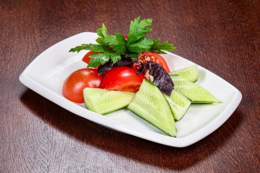 Dilimlenmiş sebzeli salata - domates, salatalık ve maydanoz