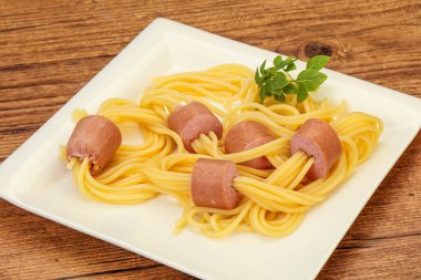 Çocuklar sosisli ve fesleğenli makarna.