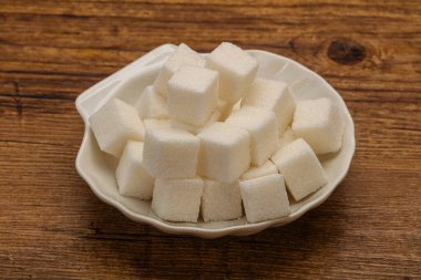 Rafine edilmiş beyaz granüllü şeker yavruları kasede.