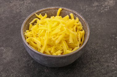 Yemek pişirmek için kasede dilimlenmiş sarı peynir.