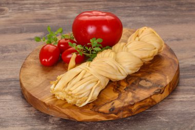 Beyaz geleneksel Pigtail peynir domates ve fesleğen yaprakları servis