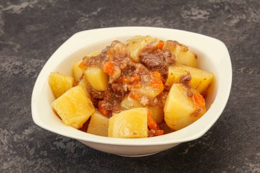 Soslu ve sebzeli kızarmış patates ve biftek.