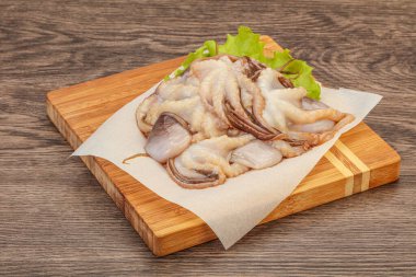 Çiğ deniz ürünleri - ahtapot tahtada pişirmek için.