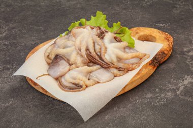 Çiğ deniz ürünleri - ahtapot tahtada pişirmek için.