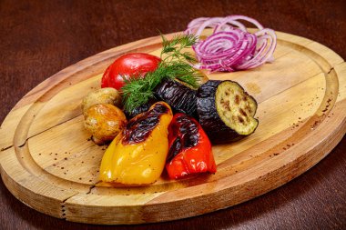 Tabakta ızgara sebze, soğan servis edildi.