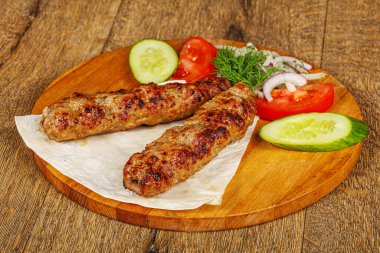 Biftek dilimlenmiş et shashlik sebze servis ediyordu.