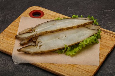 Lezzetli füme halibut balığı aperatifi keser.