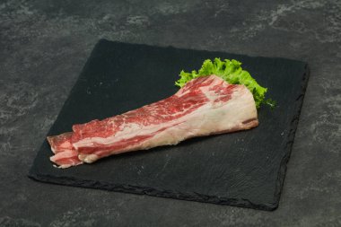 Tahtanın üzerinde çiğ domuz pastırması salata ve kekik servis edildi.