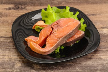 İki pembe somon balığı bifteği. Salata yaprağı.