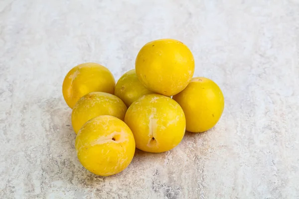 Ripe sweet yellow plum heap over background