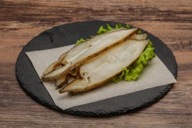 Lezzetli füme halibut balığı aperatifi keser.