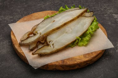 Lezzetli füme halibut balığı aperatifi keser.