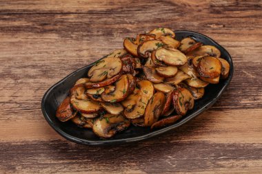 Kavrulmuş şampiyon, kasede otlar ve baharatlar var.