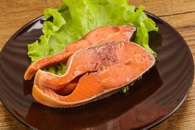 İki pembe somon balığı bifteği. Salata yaprağı.