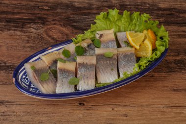 Dilimlenmiş limonla marine edilmiş ringa filetosu.