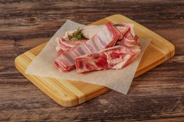 Çiğ kuzu kaburgası pişirmek için biberiye servis edilir.