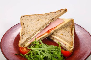 Jambonlu ve peynirli sandviç roka servis edildi.