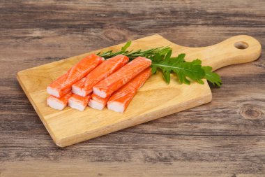 Ahşap tahtanın üzerinde yengeç çubuğu surimi