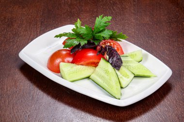 Dilimlenmiş sebzeli salata - domates, salatalık ve maydanoz