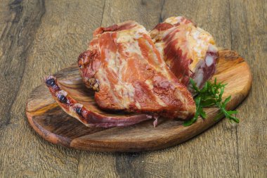 Ahşap zemin üzerinde tütsülenmiş domuz kaburgası.