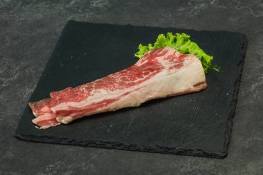 Tahtanın üzerinde çiğ domuz pastırması salata ve kekik servis edildi.