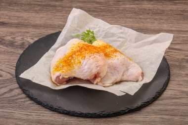 Kızartma için baharatlı çiğ tavuk budu.