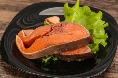 İki pembe somon balığı bifteği. Salata yaprağı.