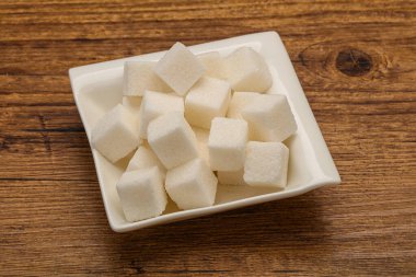 Rafine edilmiş beyaz granüllü şeker yavruları kasede.