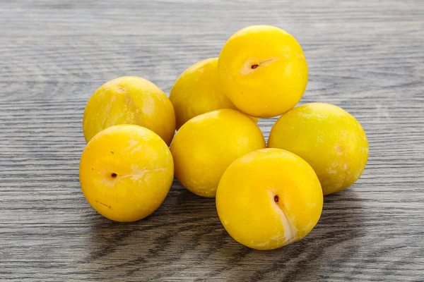 Ripe sweet yellow plum heap over background