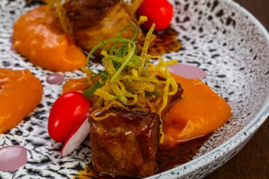 Fırında domuz, havuç sosu ve kızarmış soğan.