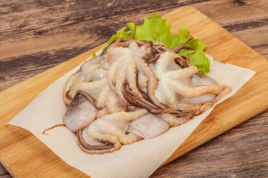 Çiğ deniz ürünleri - ahtapot tahtada pişirmek için.