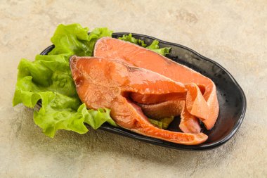 İki pembe somon balığı bifteği. Salata yaprağı.