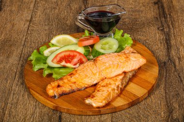 Izgara somon, sebze ve limon dilimi.