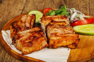 Izgara domuz eti, sebze ve soğan servis edildi.