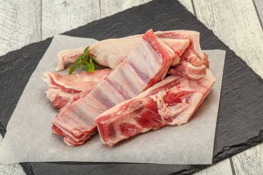 Çiğ kuzu kaburgası pişirmek için biberiye servis edilir.