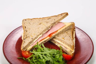 Jambonlu ve peynirli sandviç roka servis edildi.