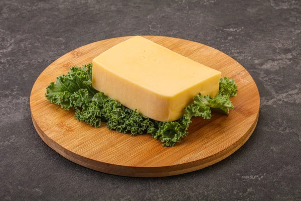 おいしい黄色ボード上のティルシターチーズレンガ — ストック写真