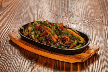 Kızarmış domuz ve patates ile tava sebze servis edildi.