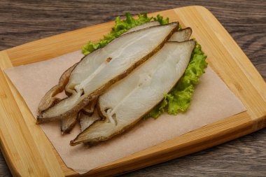 Lezzetli füme halibut balığı aperatifi keser.