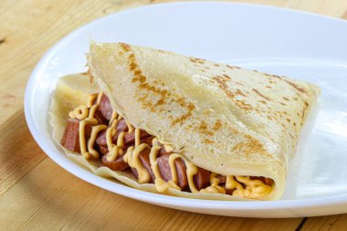 Dilimlenmiş sosis ve hardal soslu krep.