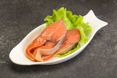 İki pembe somon balığı bifteği. Salata yaprağı.